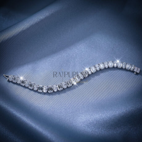 A luxurious sterling silver tennis bracelet featuring alternating emerald-cut and oval-cut moissanite stones