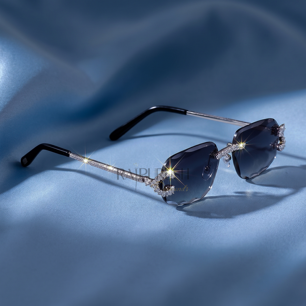Luxury rimless sunglasses with dark tinted lenses and iced out moissanite stone frames resting on a smooth blue silk background.