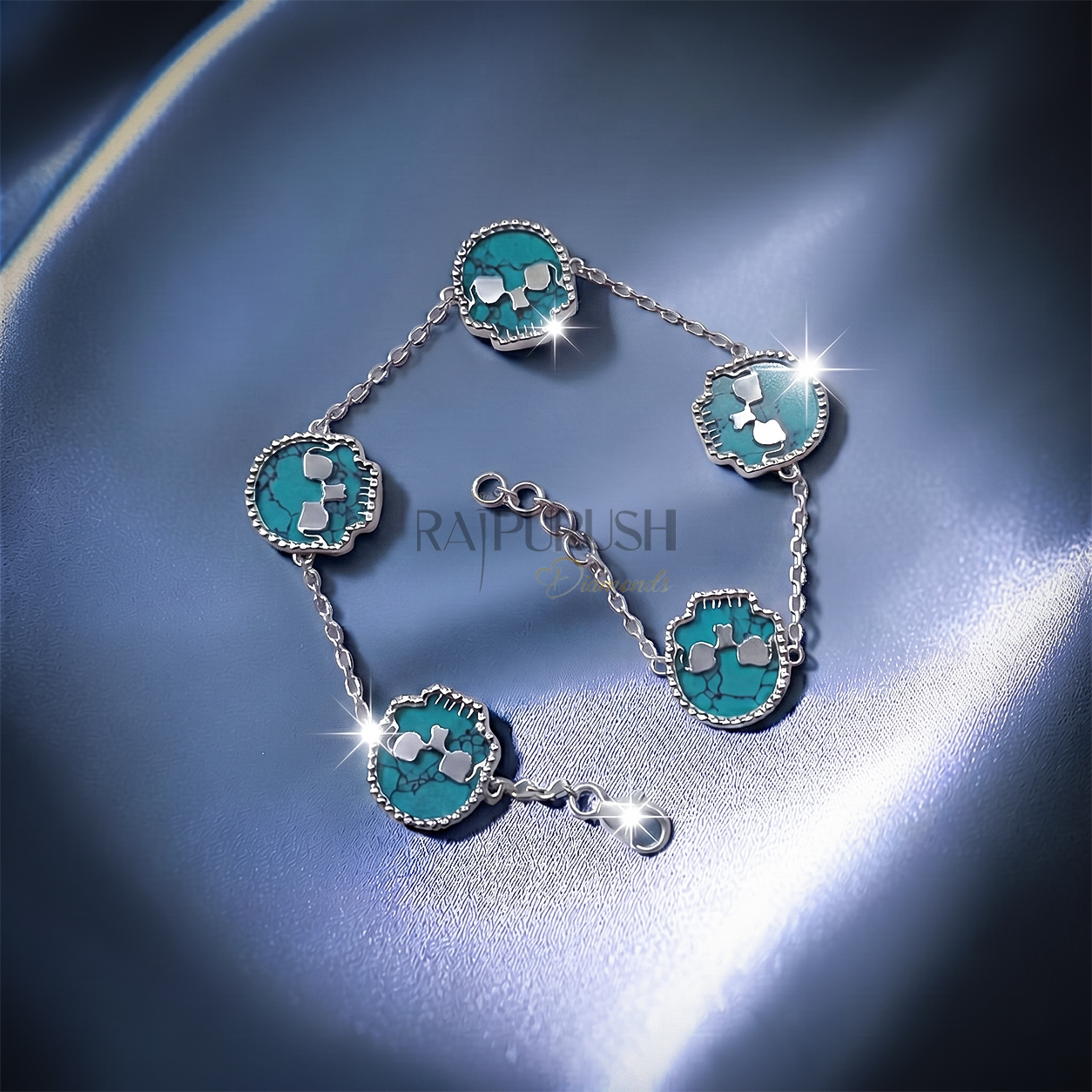 Unisex 925 sterling silver hip hop station bracelet featuring five skull-shaped turquoise stones framed with milgrain borders.Full length view of an edgy streetwear turquoise skull link chain bracelet laid out on a shimmering blue satin surface.