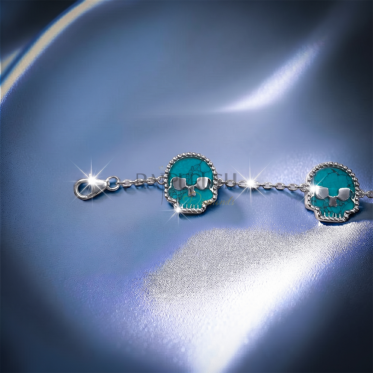 Unisex 925 sterling silver hip hop station bracelet featuring five skull-shaped turquoise stones framed with milgrain borders.Full length view of an edgy streetwear turquoise skull link chain bracelet laid out on a shimmering blue satin surface.