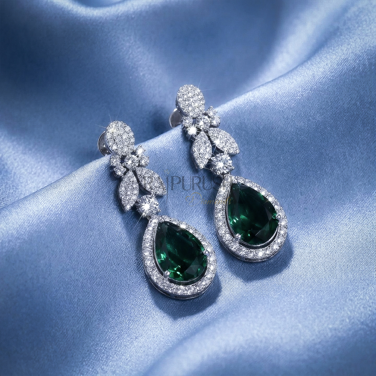 Stunning round brilliant moissanite tennis necklace featuring green sapphire pear cut diamond alternative teardrop clusters on a luxurious blue silk background.