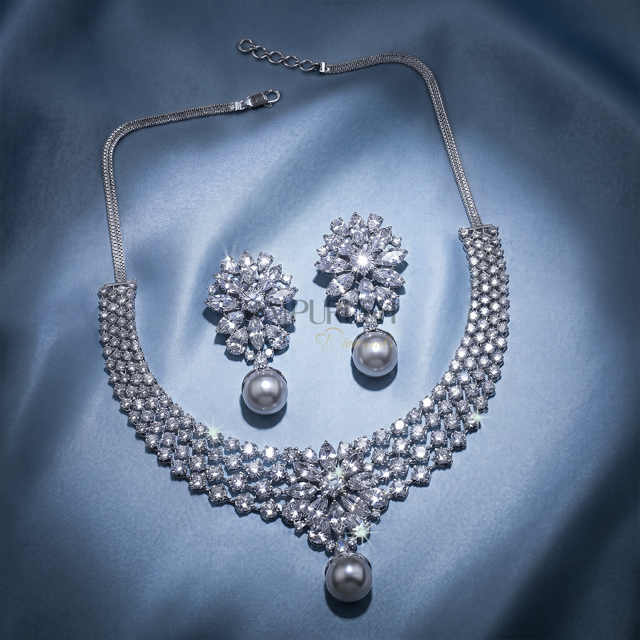 Stunning V-shaped cascading fringe moissanite statement necklace in premium 925 sterling silver showcased beautifully on a blue silk background.