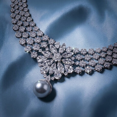 Stunning V-shaped cascading fringe moissanite statement necklace in premium 925 sterling silver showcased beautifully on a blue silk background.