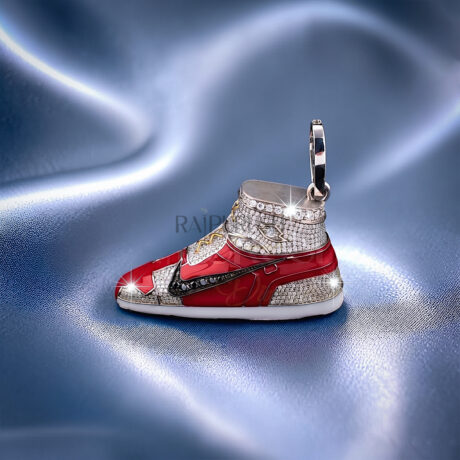 Detailed dynamic angle of a silver hip hop sneaker pendant completely flooded with round brilliant moissanite stones and vibrant red enamel accents.