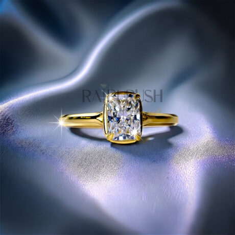 1 carat radiant cut solitaire engagement ring in 14k yellow gold plated sterling silver on a silk background.Side profile of a 1ct elongated radiant cut diamond simulant wedding ring with a modern cathedral bezel setting.