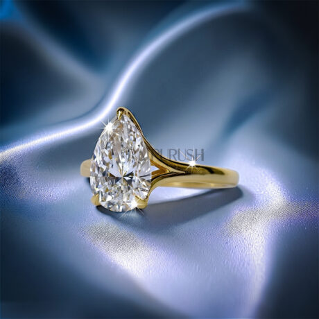 1 carat pear cut solitaire engagement ring in 14k yellow gold plated sterling silver, Side profile of a 1ct teardrop diamond simulant wedding ring showcasing a split shank cathedral setting. Under-gallery view of a gold plated pear cut solitaire ring showing the elegant open basket framework.