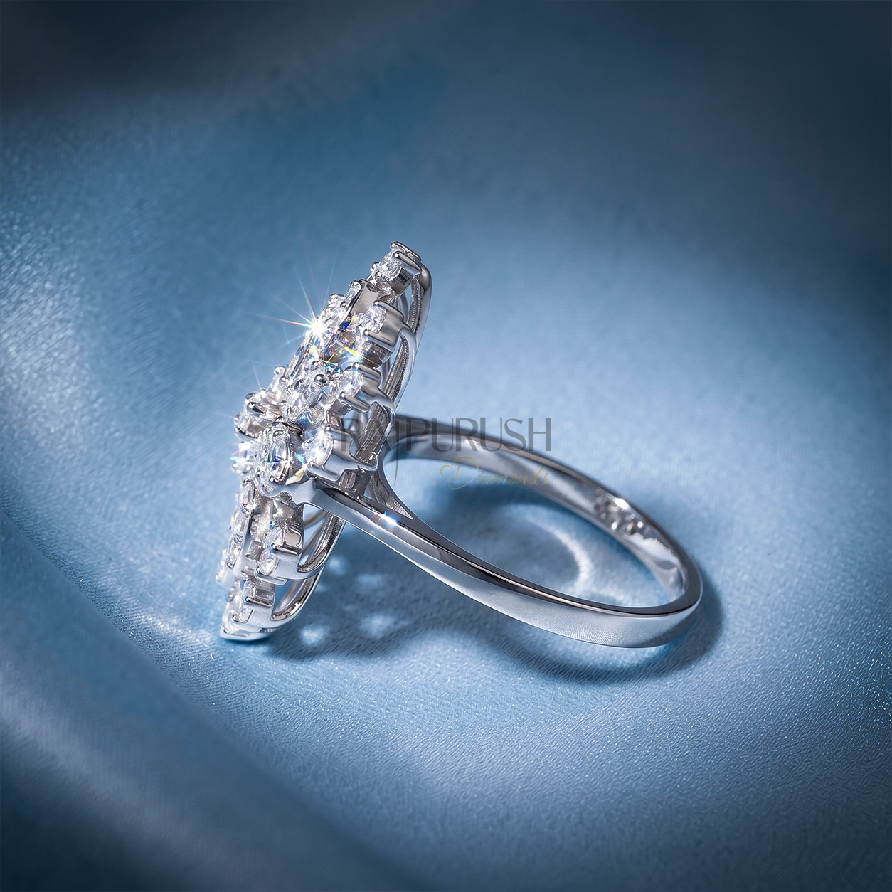 Brilliant cut moissanite snowflake statement cluster cocktail ring in 925 sterling silver beautifully centered on a shimmering blue silk background.