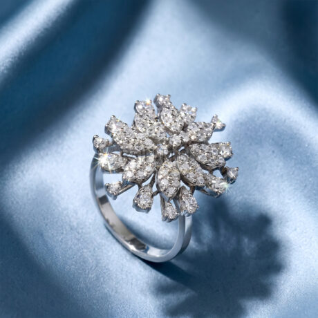 Brilliant cut moissanite snowflake statement cluster cocktail ring in 925 sterling silver beautifully centered on a shimmering blue silk background.
