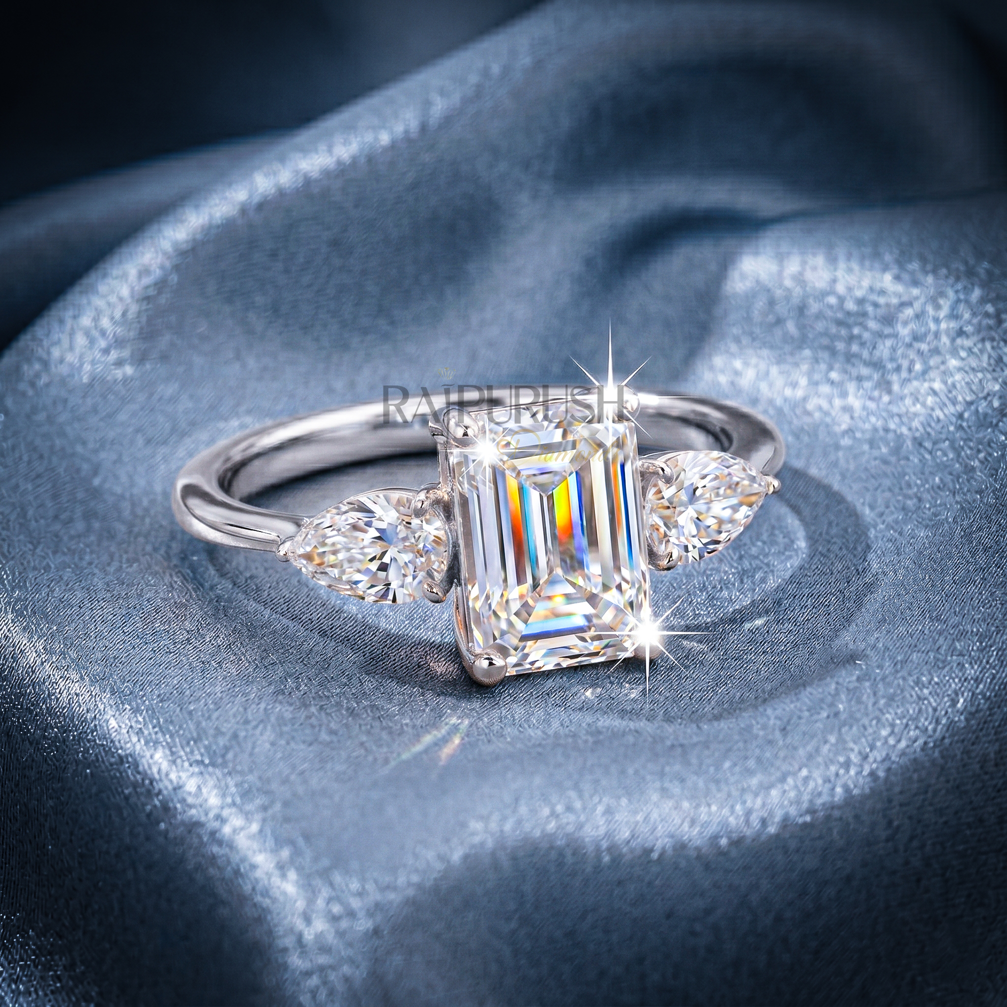 Elegant emerald-cut moissanite engagement ring with pear-shaped side stones, finished in 14k yellow/rose gold plating.