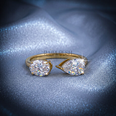 A modern "Toi et Moi" style engagement ring featuring pear and oval cut moissanite stones, finished in 14k yellow/rose gold plating.