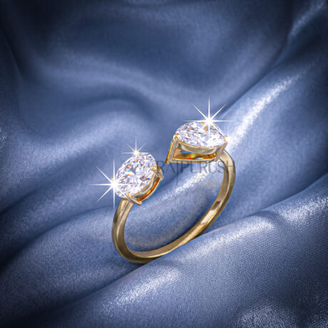 A modern "Toi et Moi" style engagement ring featuring pear and oval cut moissanite stones, finished in 14k yellow/rose gold plating.