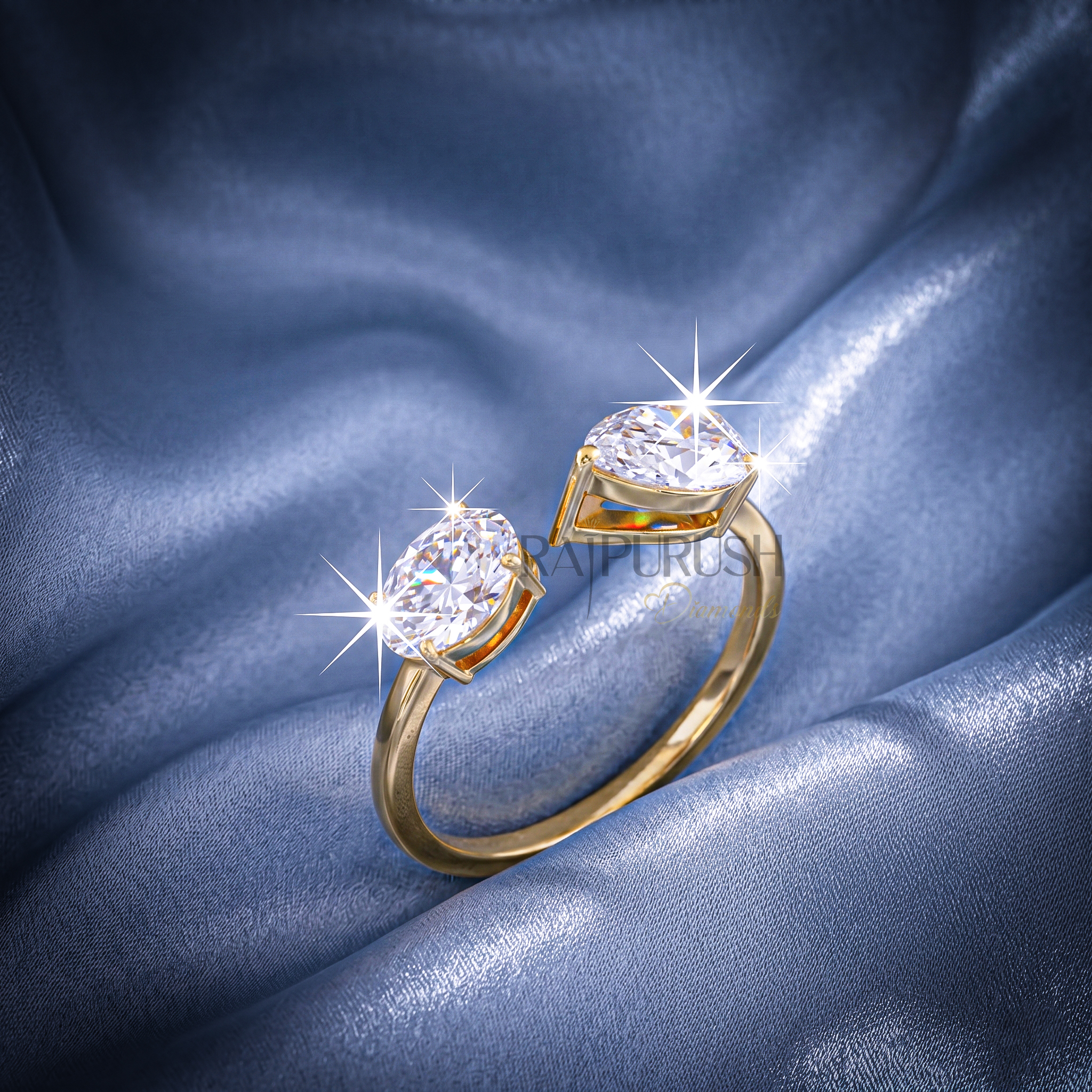 A modern "Toi et Moi" style engagement ring featuring pear and oval cut moissanite stones, finished in 14k yellow/rose gold plating.