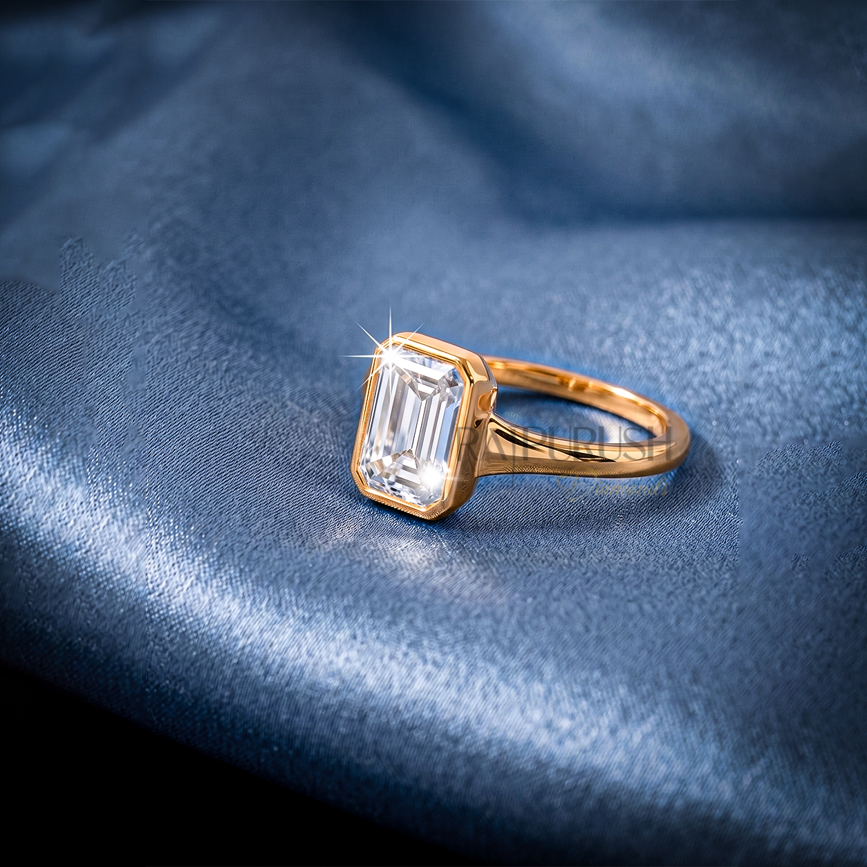 A stunning 1ct emerald cut moissanite engagement ring featuring a secure full bezel setting on a polished 14k gold band