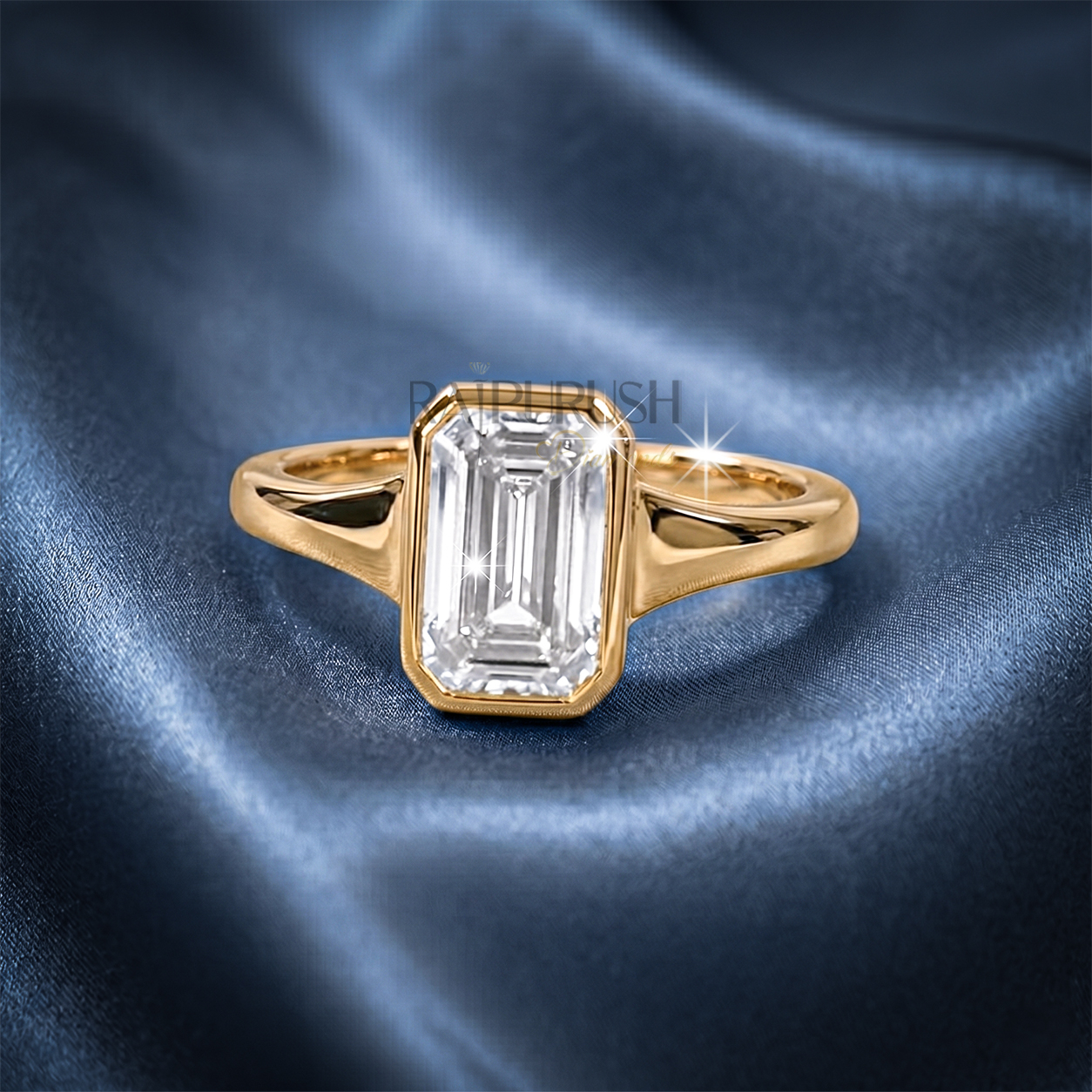 A stunning 1ct emerald cut moissanite engagement ring featuring a secure full bezel setting on a polished 14k gold band