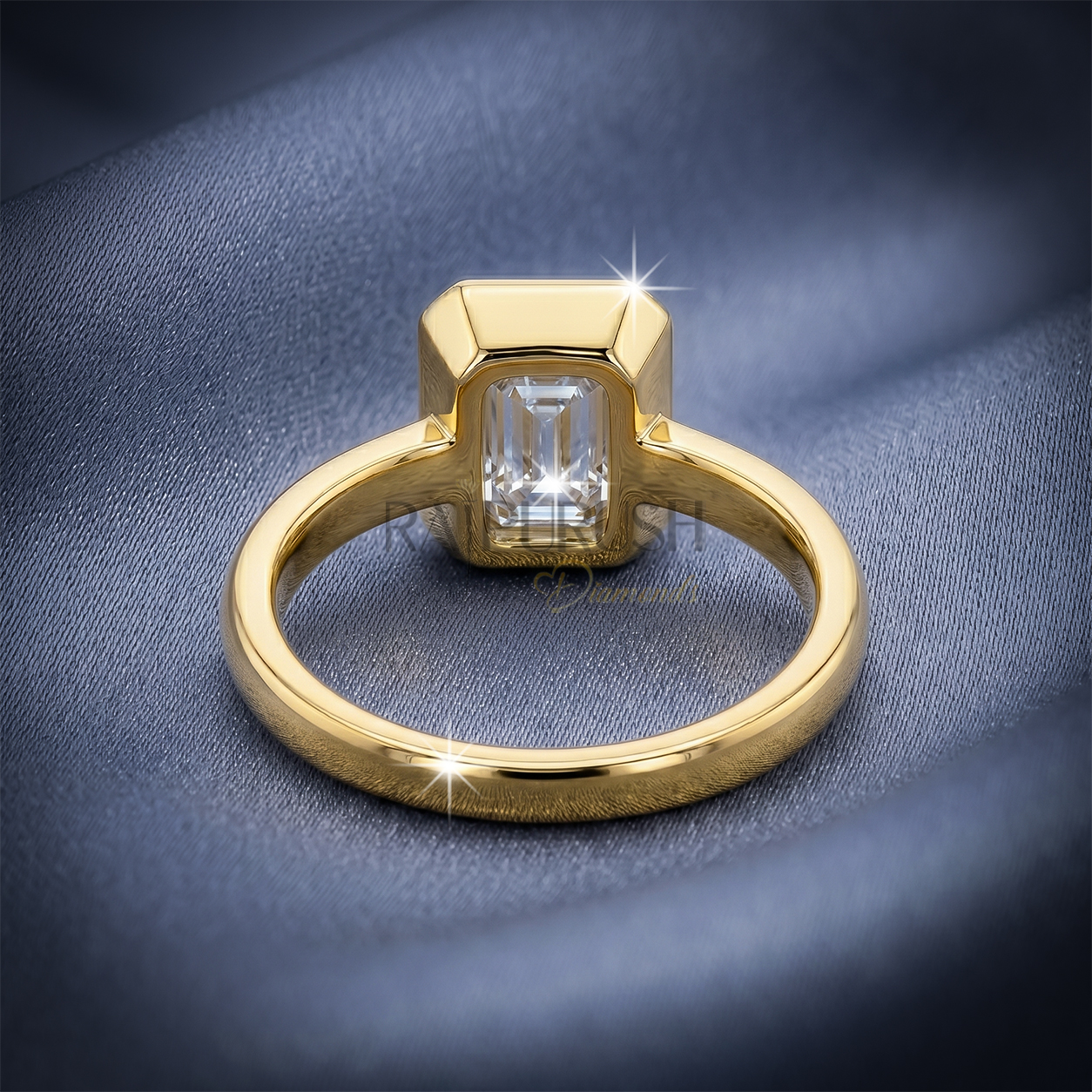 A stunning 1ct emerald cut moissanite engagement ring featuring a secure full bezel setting on a polished 14k gold band