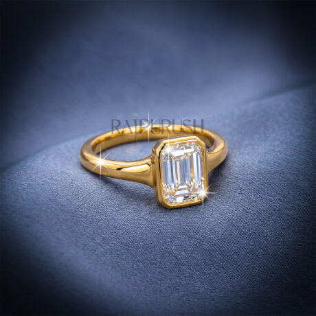 A stunning 1ct emerald cut moissanite engagement ring featuring a secure full bezel setting on a polished 14k gold band