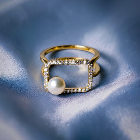 Modern geometric open frame statement ring in 14k gold plated silver featuring a floating white pearl and micro pave moissanite border on a blue silk background.