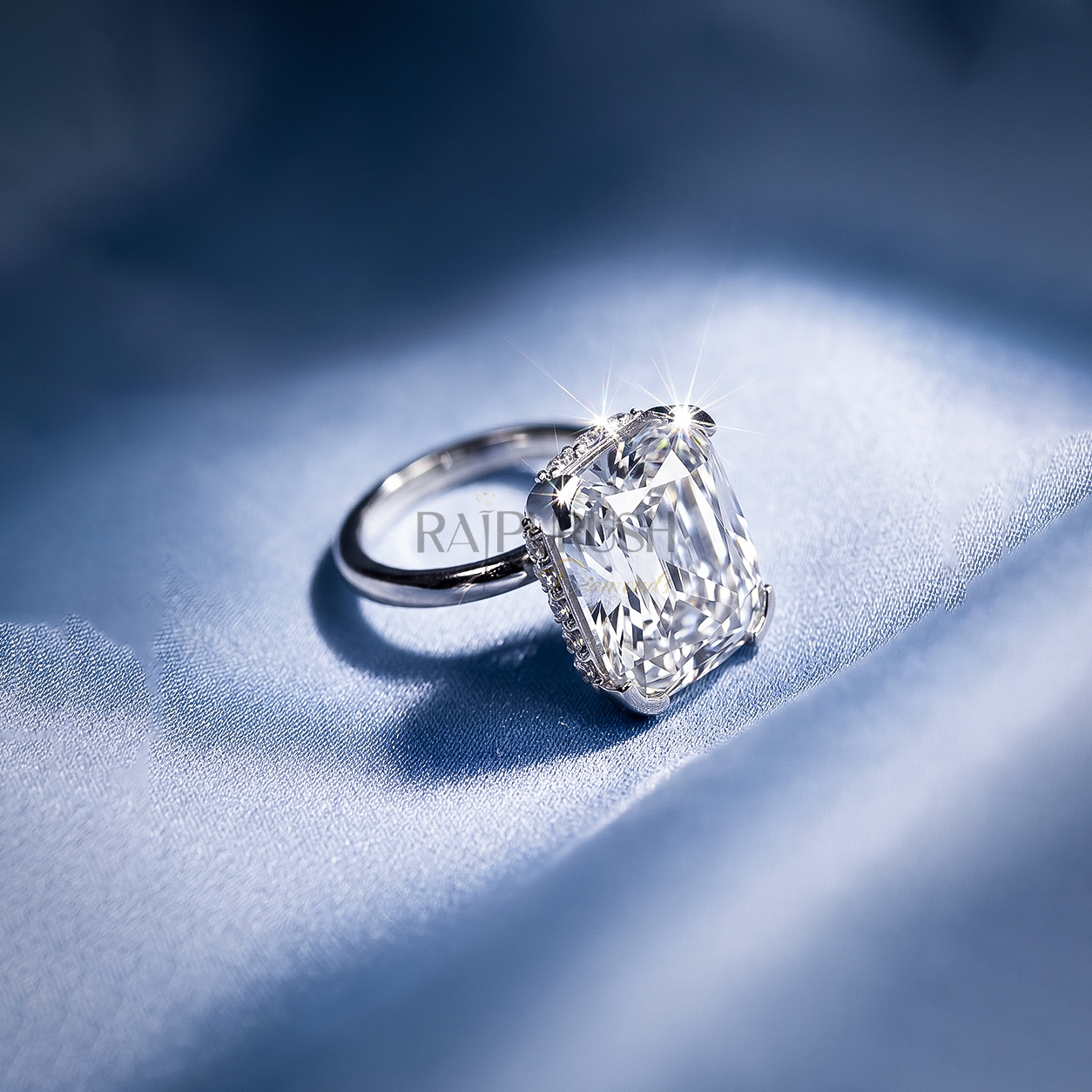 Elongated Cushion cut moissanite solitaire engagement ring in solid silver showcasing incredible crushed ice brilliance on blue silk.