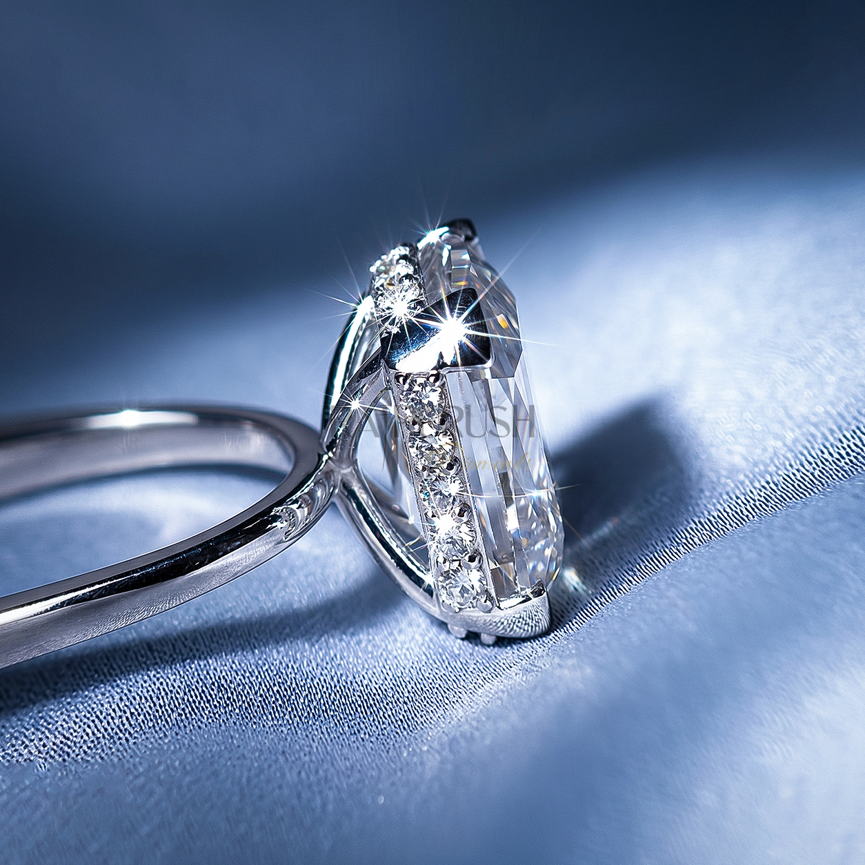 Elongated Cushion cut moissanite solitaire engagement ring in solid silver showcasing incredible crushed ice brilliance on blue silk.