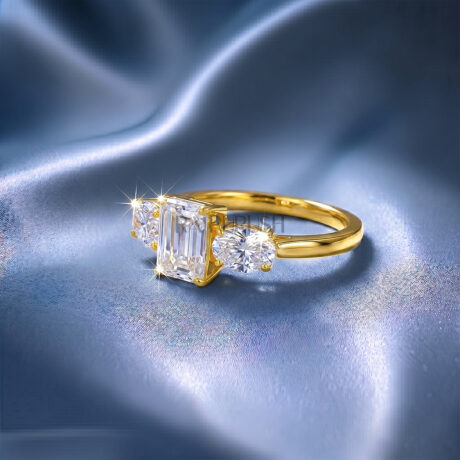 Vintage-inspired emerald cut moissanite engagement ring featuring a three-stone layout in 925 sterling silver on blue silk.